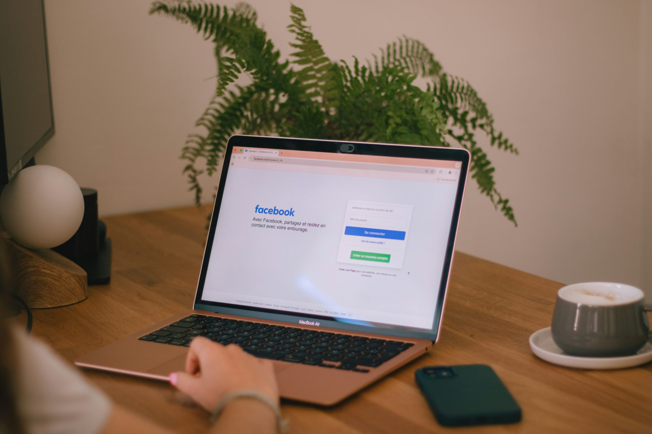 Person sitzt zuhause am Laptop und scrollt durch Social Media